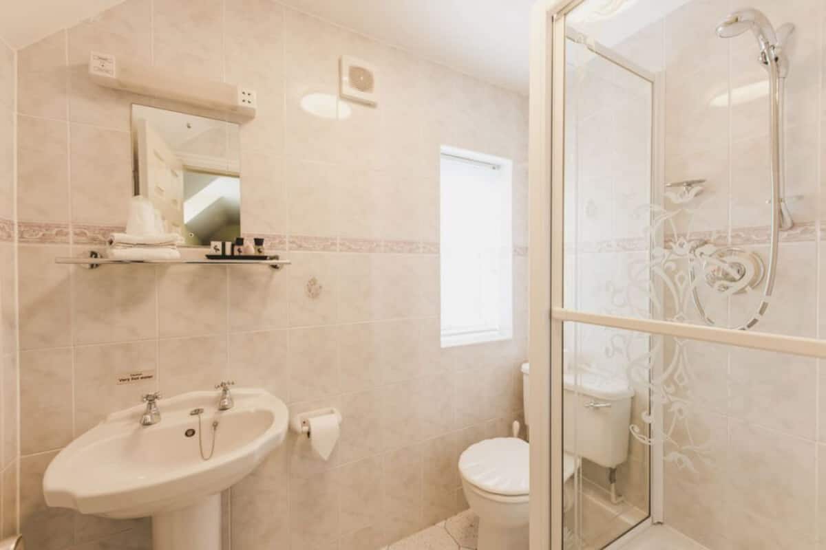 A bathroom with a sink, toilet, and glass-enclosed shower.
