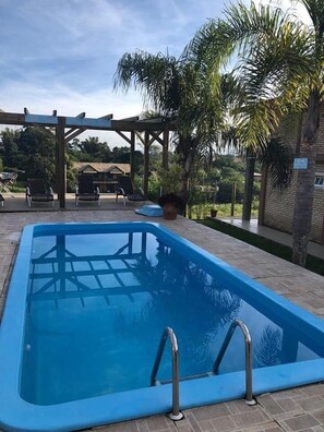 室外游泳池，開放時間為 09:00 至 21:00，提供泳池遮陽傘和日光浴躺椅