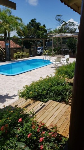 室外游泳池，開放時間為 09:00 至 21:00，提供泳池遮陽傘和日光浴躺椅