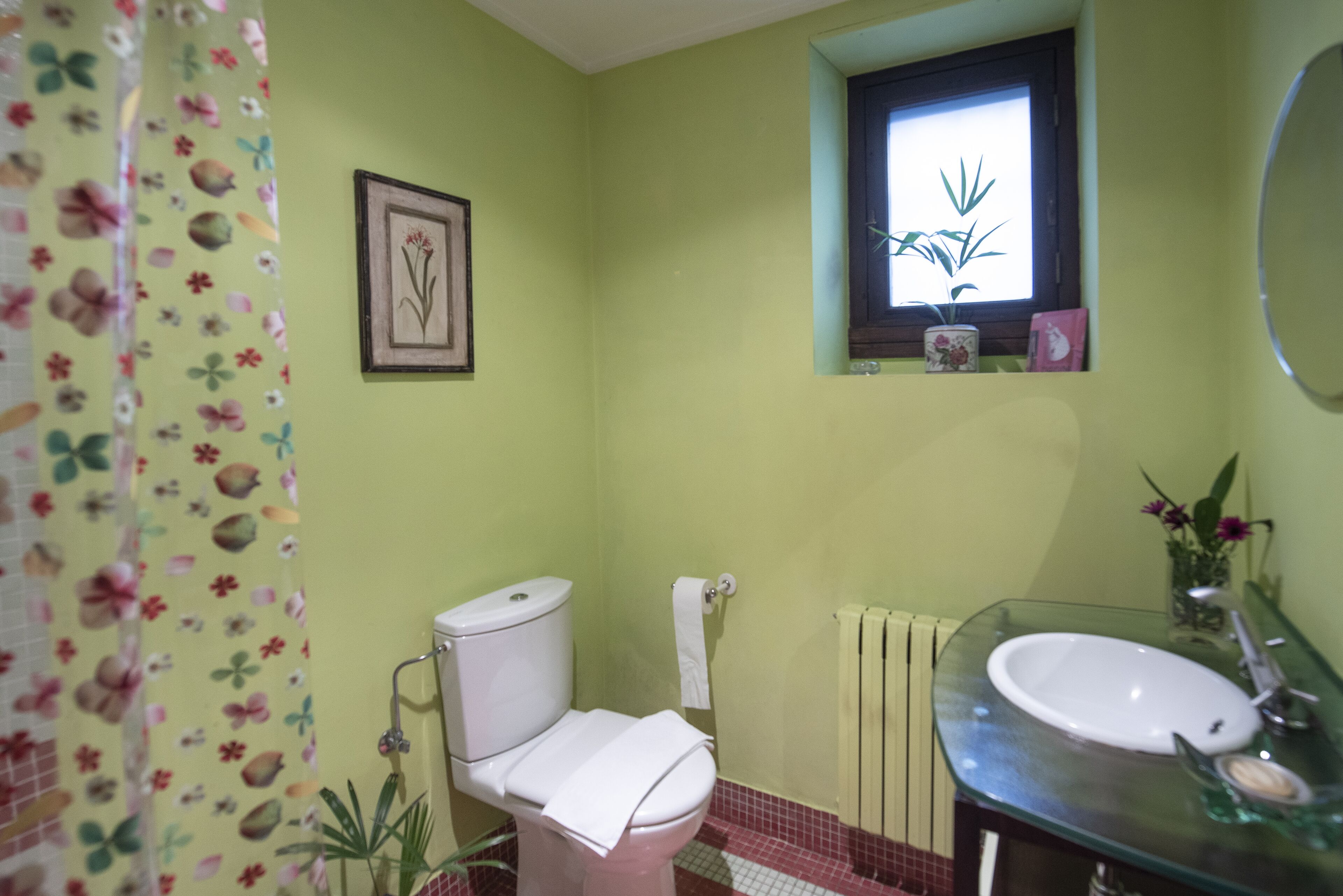 A bathroom with a toilet, sink, and shower curtain.