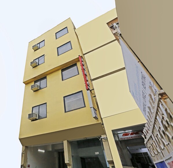 Um edifício com vários andares, janelas e aparelhos de ar condicionado.