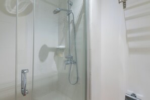 Regadera, secadora de cabello, toallas, papel de baño 