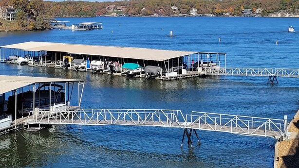 A marina with docked boats, a covered boat ramp, and a clear view of the surrounding landscape. - LAKEFRONT End Unit Condo at 3 Seasons @ 21MM  (Osage Beach)