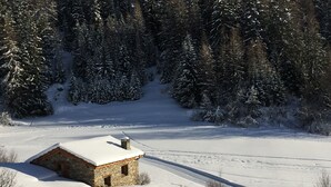 A stone cabin with a snow-covered roof in a snowy landscape. - Apartment for 4 people on the slopes (Lanslevillard)