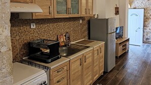 Una cocina con armarios de madera, salpicadero de azulejos, refrigerador y estufa.