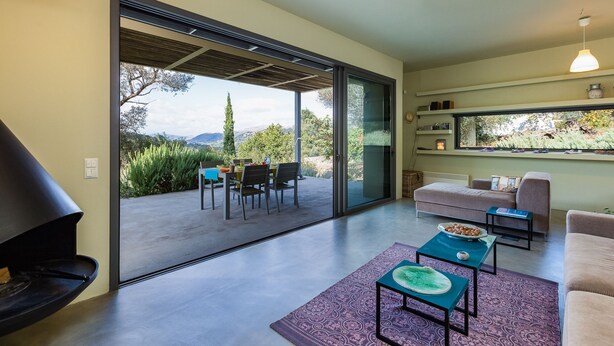 A modern living room with a sliding glass door leading to an outdoor patio. - Tessera Villa, a Serene Escape in Nature with Pool (Spili, Rethymno)