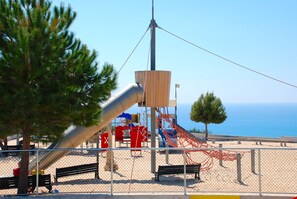 A playground with a slide, swings, and a climbing structure.