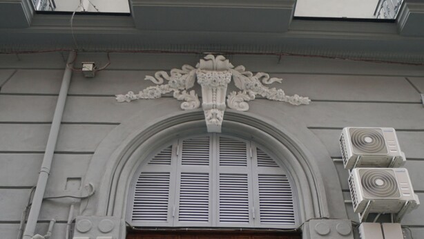 A large wooden double door with a decorative arch above it. - Naporà (Naples)