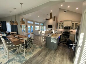Enjoy a spacious open-plan living area with a dining table and comfortable seating, plus a well-equipped kitchen with a large island.