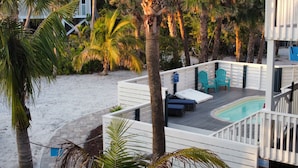 Eine Terrasse mit Pool, Sitzgelegenheiten im Freien und Palmen.