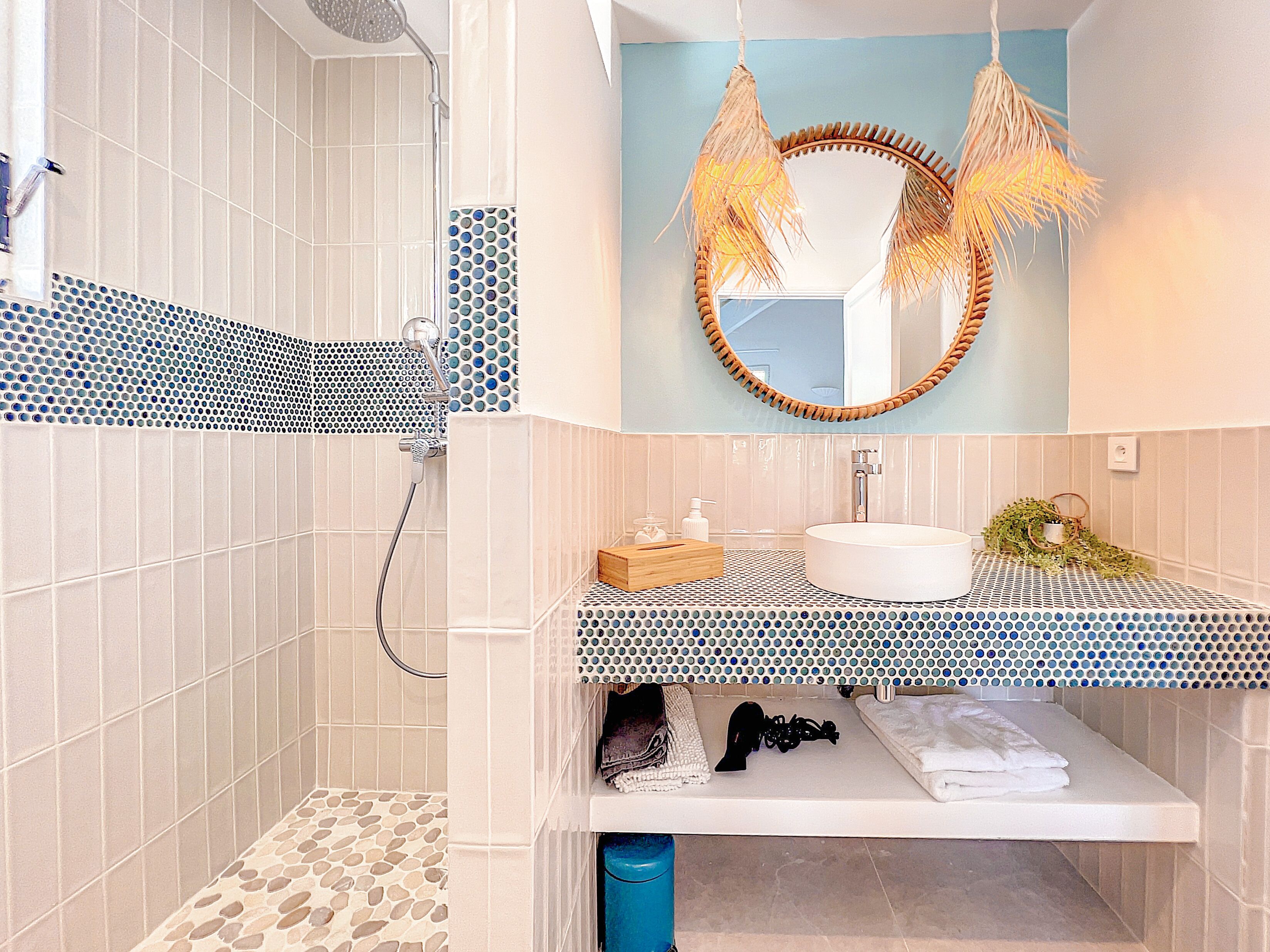 A bathroom with a shower, a sink, and a mirror.