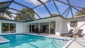 Una piscina cristallina blu con tetto in vetro, sedie a sdraio e una zona solarium.