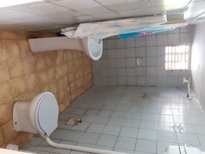 Bathroom features a toilet, bidet, and window with bars.