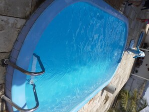 Enjoy a refreshing swim in the pool surrounded by a tiled deck with a handrail for added safety.