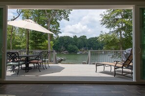 Una terraza con mobiliario exterior y vista a un lago.