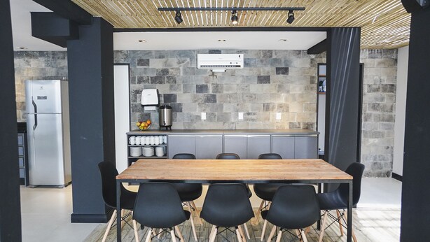 Eine moderne Küche mit Steinrückwand, einer Kaffeemaschine und einem eingebauten Kühlschrank.