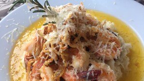 Garnelen mit Käse und Kräutern auf einem weißen Teller.