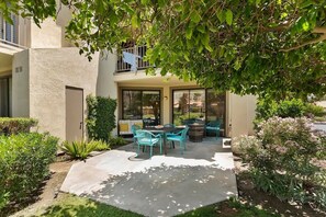 A patio with outdoor furniture, a fire pit, and a view of the neighborhood. - PGA WEST, 30 NIGHT MIN. SPECTACULAR MT & WATER VIEW! STUNNING INTERIOR, PS VIBES (La Quinta)