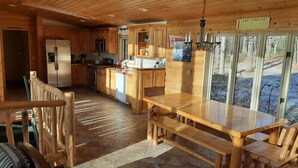 A wooden cabin with a kitchen, dining area, and a view of the outdoors. - Round Lake Cabin Retreat (Hayward)
