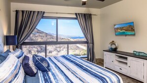 A bedroom with a bed, curtains, a ceiling fan, a TV, and a view of the outdoors. - PERFECT for large families/groups! 7 luxurious Guest Suites. Amazing Views! (cabo san lucas)