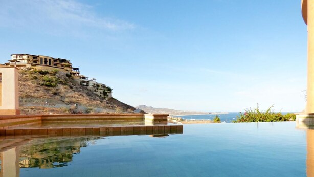 A clear infinity pool with a view of a hillside and distant landscape. - PERFECT for large families/groups! 7 luxurious Guest Suites. Amazing Views! (cabo san lucas)