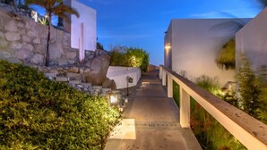 A pathway leading to a building with a stone wall and a wooden railing. - PERFECT for large families/groups! 7 luxurious Guest Suites. Amazing Views! (cabo san lucas)