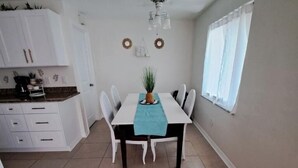 Un espace repas comprenant une table, des chaises et un ventilateur de plafond.