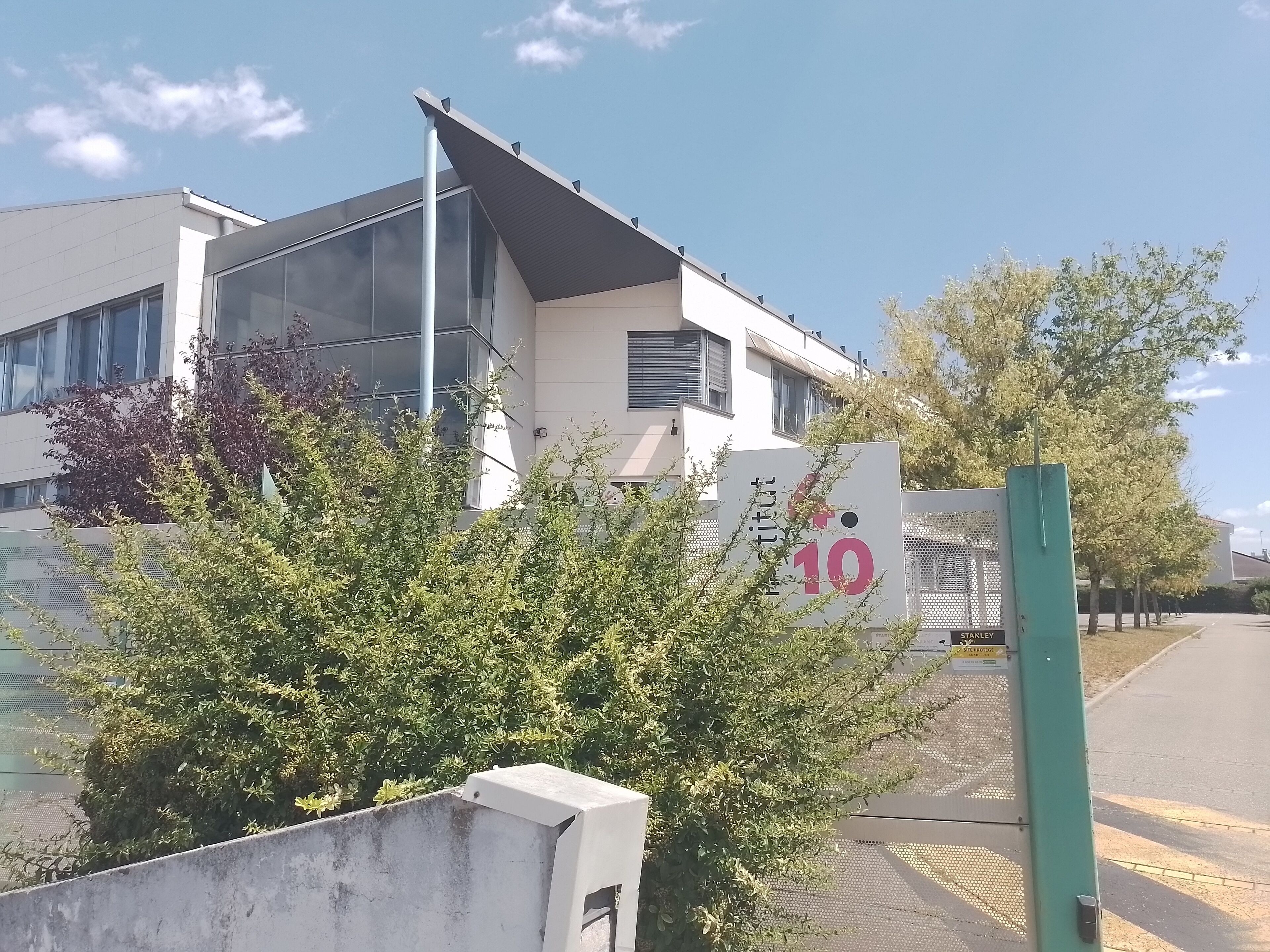 Een modern gebouw met een groot raam en een bord met het nummer 10.