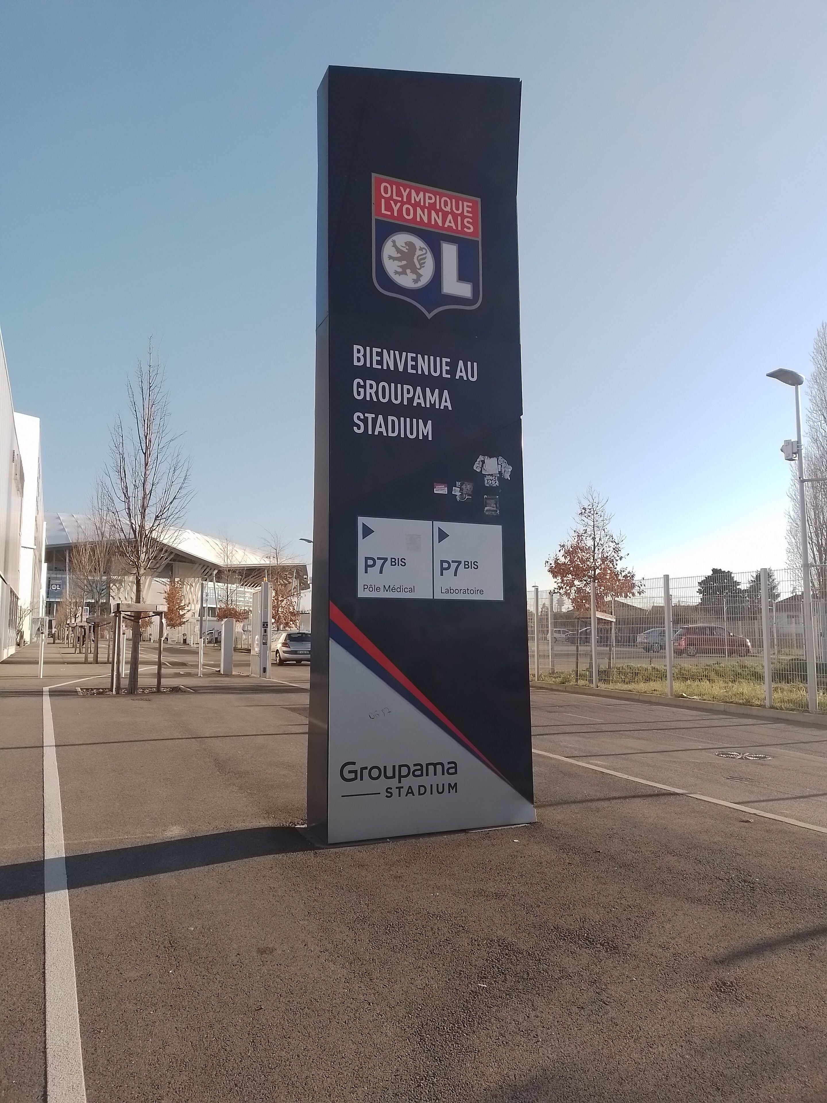 A welcome sign for Groupama Stadium with directional arrows and entrance labels.