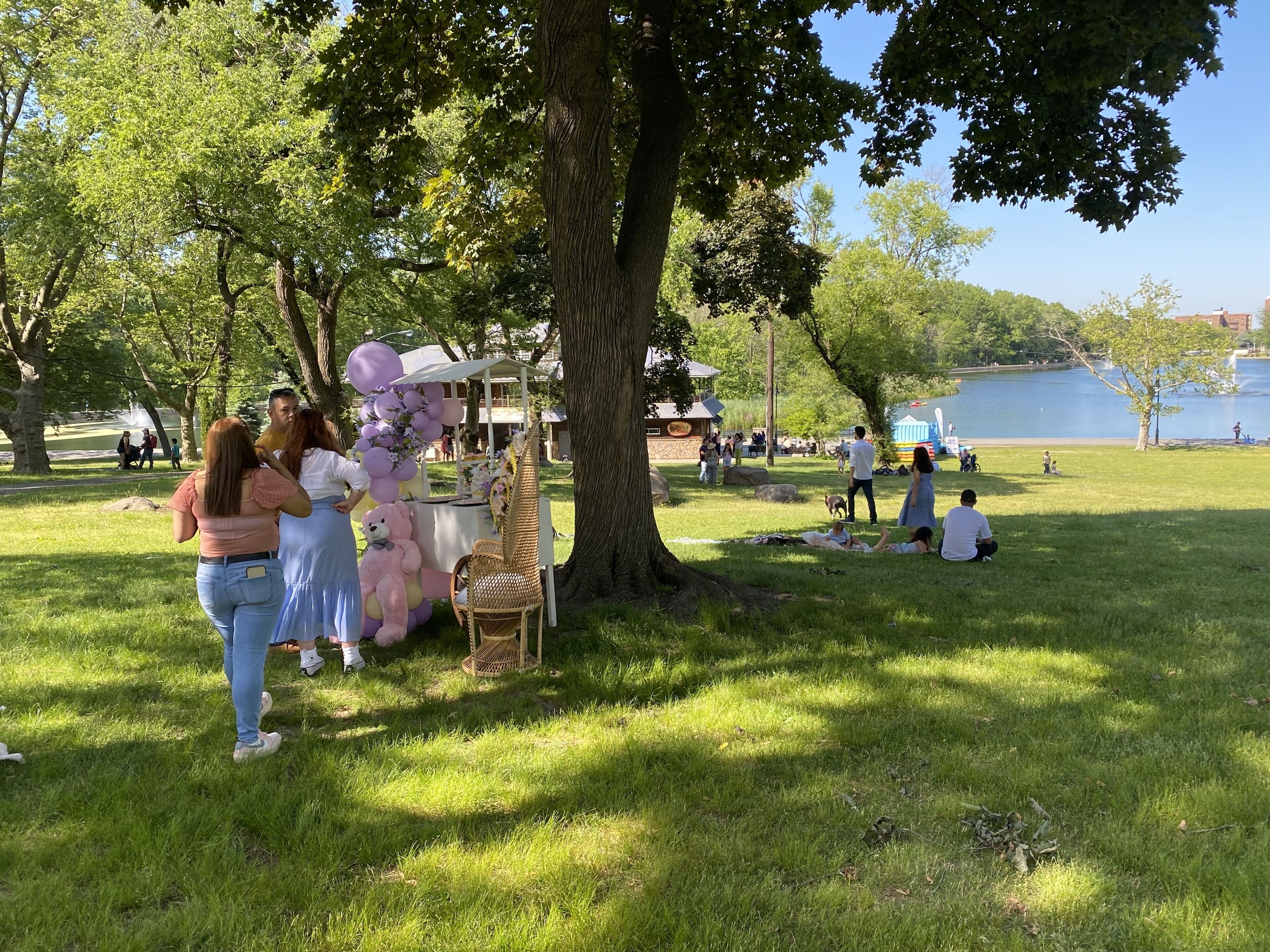Un parc avec un kiosque, des tables de pique-nique et un lac en arrière-plan.