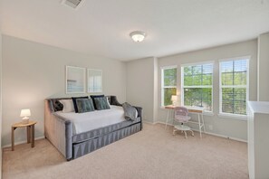 A bedroom with a bed, a desk, and a chair. - Family friendly w/ beautiful pool, SPA, and BBQ terrace! (Tomball)