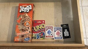 Een lade met Jenga, UNO, Bicycle kaarten en 5 dobbelstenen.