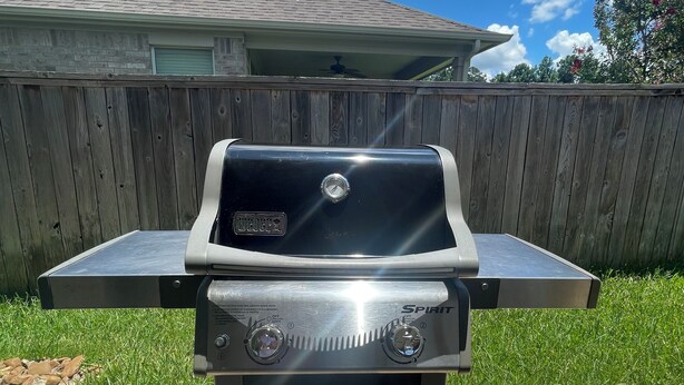 Een roestvrijstalen buitenbarbecue met een digitaal display, twee bedieningsknoppen en een vlakke bovenkant.