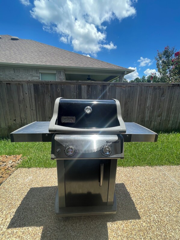 A stainless steel outdoor grill with a digital display, two control knobs, and a flat top.