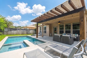 A backyard with a swimming pool, outdoor seating, and a pergola. - Family friendly w/ beautiful pool, SPA, and BBQ terrace! (Tomball)