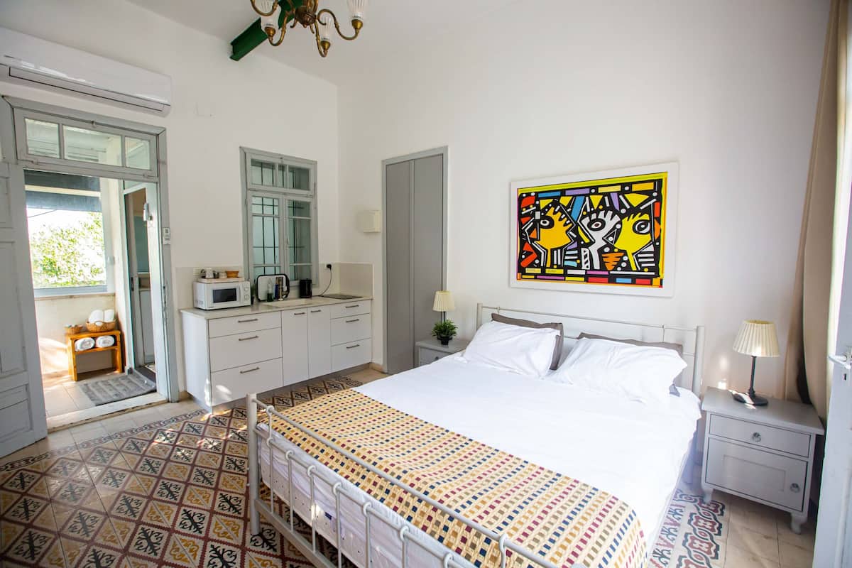 Een slaapkamer met een bed, nachtkastje en een raam.