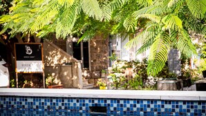Une piscine à l’eau d’un bleu limpide, entourée de verdure.