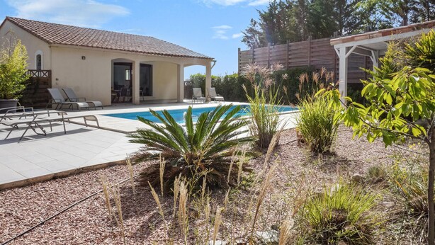 A pool area with lounge chairs and a covered patio.