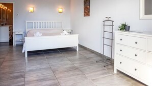 A bedroom with a bed, bedside tables, a dresser, and a ladder.