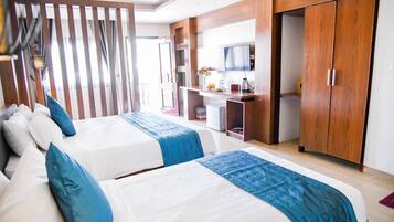 Una habitación de hotel con dos camas, televisión, escritorio y armario.