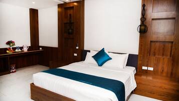 Une chambre moderne avec un cadre de lit en bois, une literie blanche et un coussin décoratif bleu.