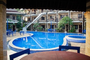 A hotel with a central swimming pool, outdoor seating, and a multi-story building with balconies. - Diamond Resort Vang Vieng (Vang Vieng)