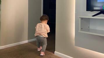 Guests can walk down the hallway to a TV mounted on the wall.