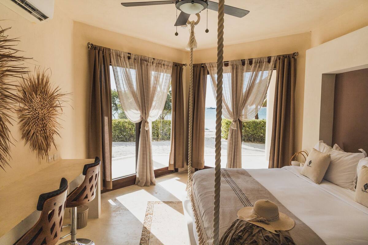 Un dormitorio con cama, ventilador de techo y vistas al exterior.