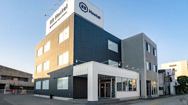 Un hostal moderno con un letrero llamativo, amplias ventanas y un diseño limpio y contemporáneo.