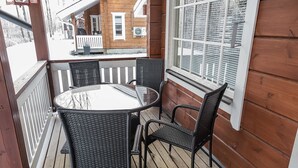 A wooden deck with a glass-top table and four wicker chairs. - Lepolinna b by Interhome (Nilsiä)