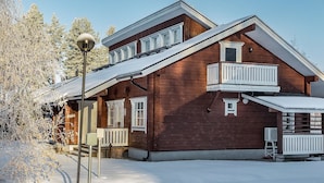 A wooden house with a sloped roof, multiple windows, and a balcony. - Lepolinna b by Interhome (Nilsiä)