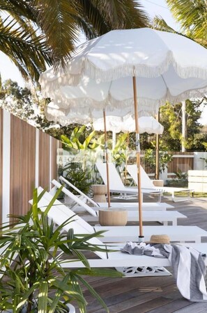 Una piscina al aire libre, sillones reclinables de piscina