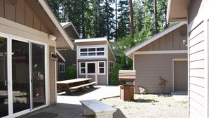 A patio area with a picnic table, a bench, and a small outdoor kitchen.