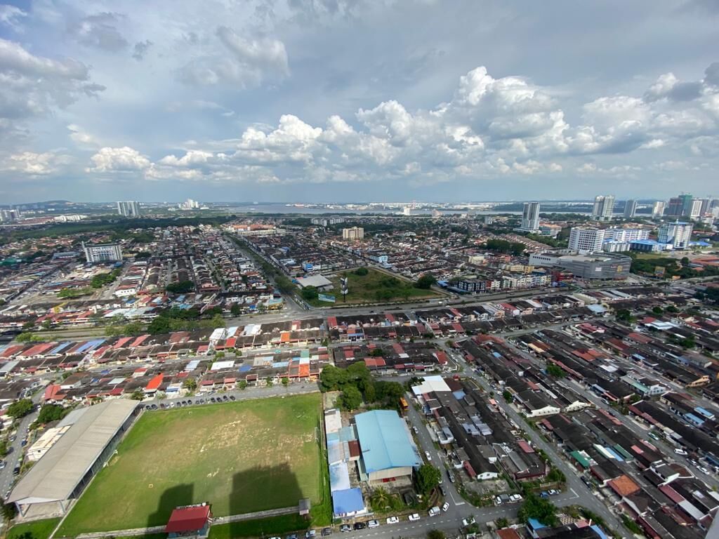 An aerial view of a cityscape with dense urban development, including high-rise buildings and a mix of residential and commercial structures.